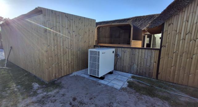 SPRSUN Pompe &agrave; chaleur de piscine Ocean Series install&eacute;e &agrave; c&ocirc;t&eacute; d'une piscine de jardin europ&eacute;enne 